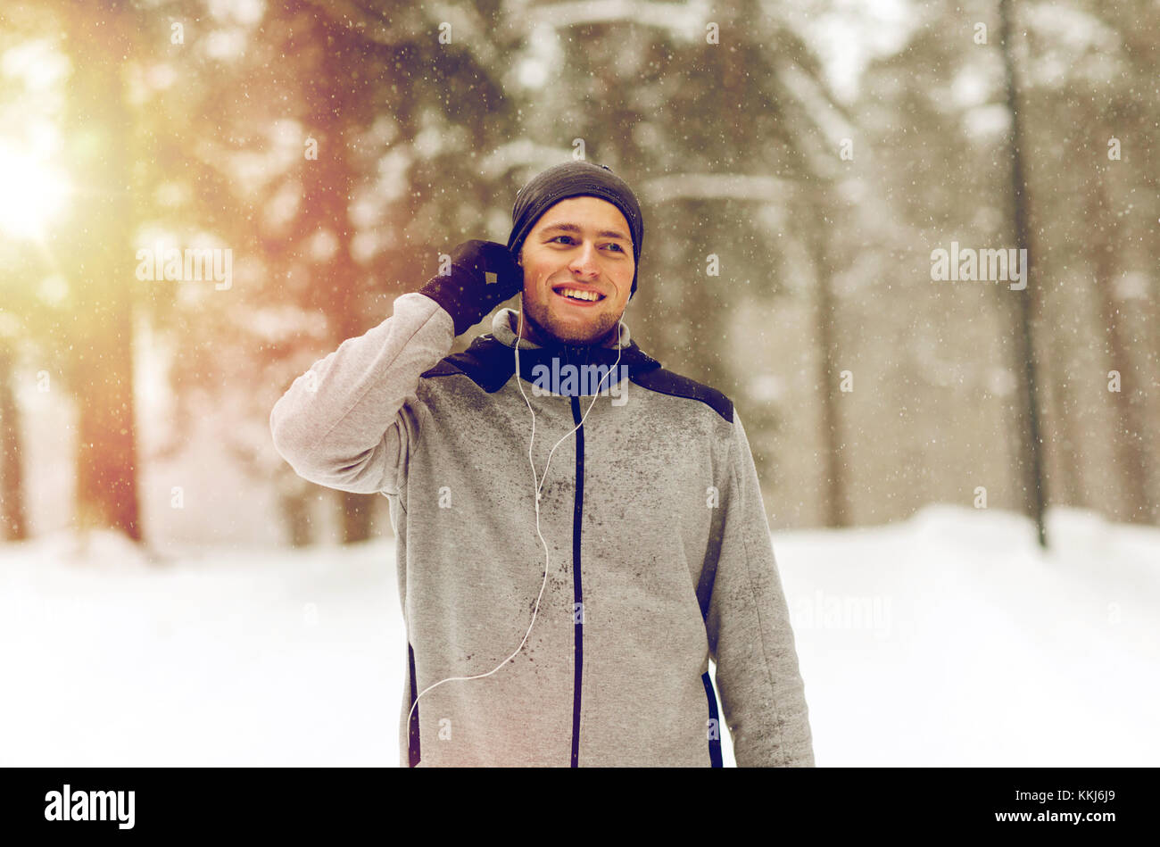 happy sports man with earphones in winter forest Stock Photo