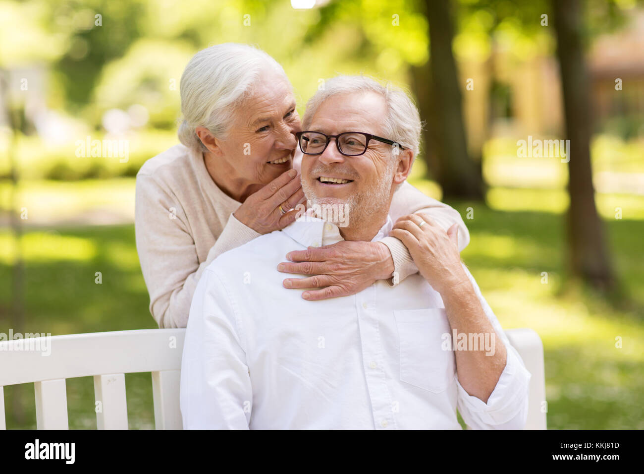 happy senior couple sitting on bench at park Stock Photo - Alamy