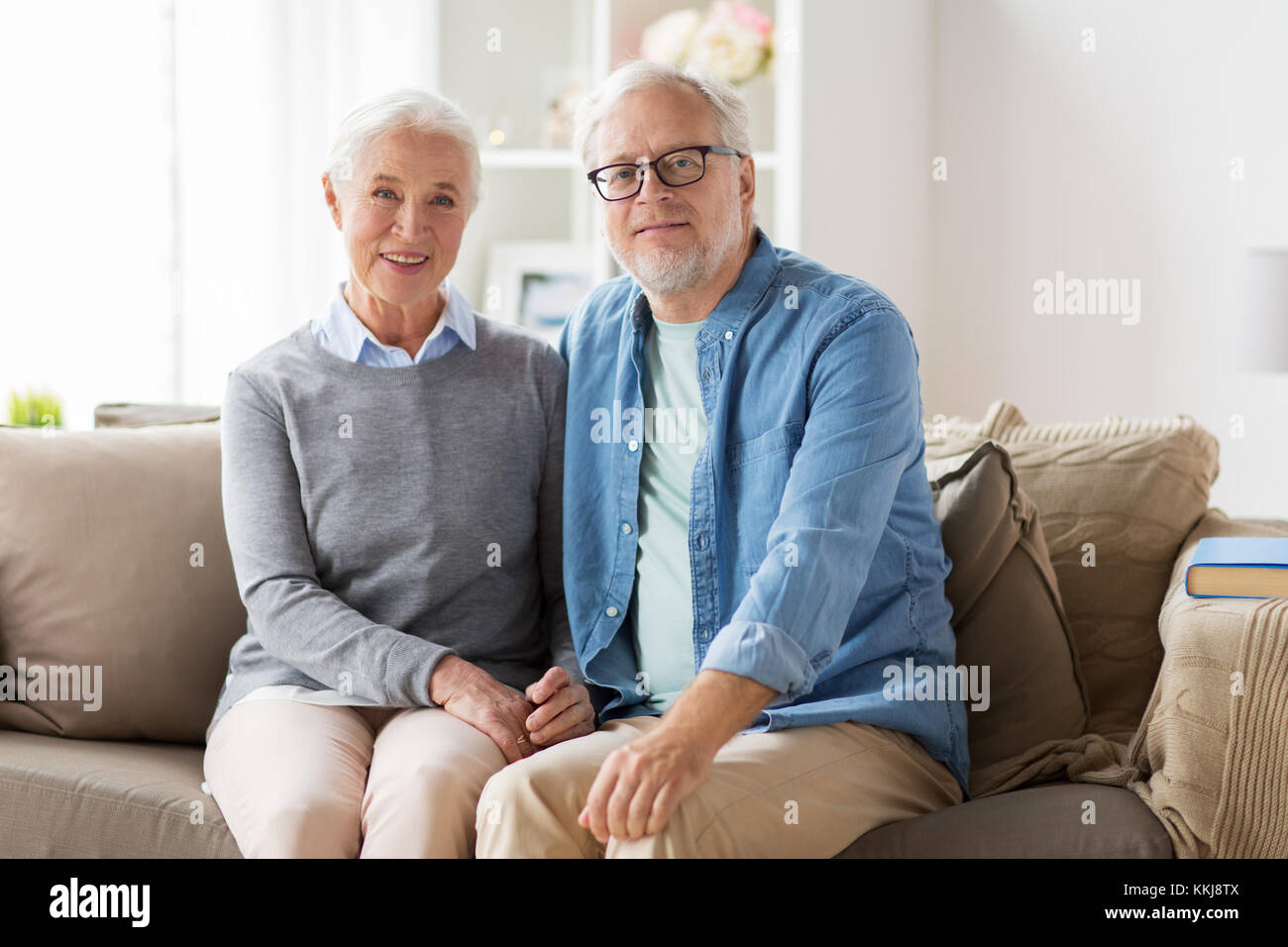happy senior couple sitting on sofa at home Stock Photo - Alamy
