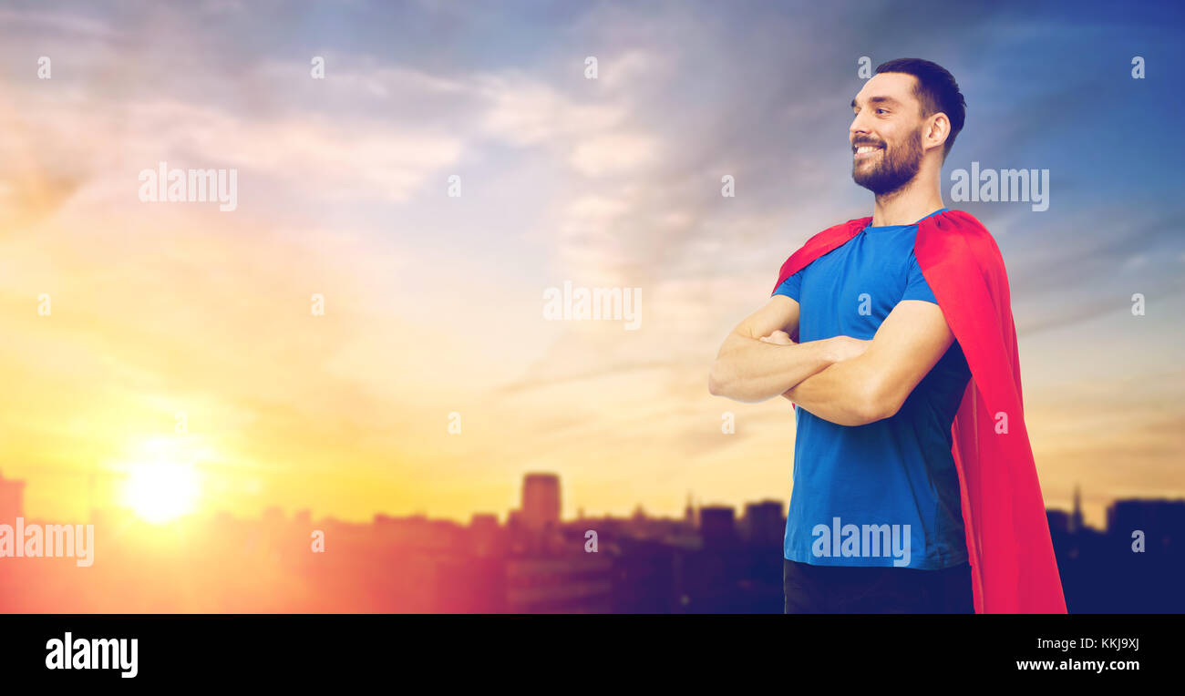 man in red superhero cape over city background Stock Photo - Alamy
