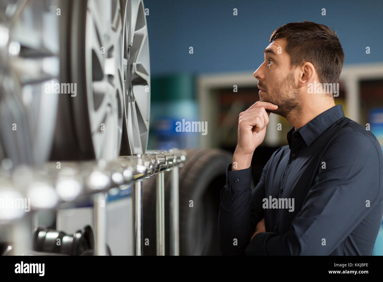 male customer choosing wheel rims at car service Stock Photo Alamy