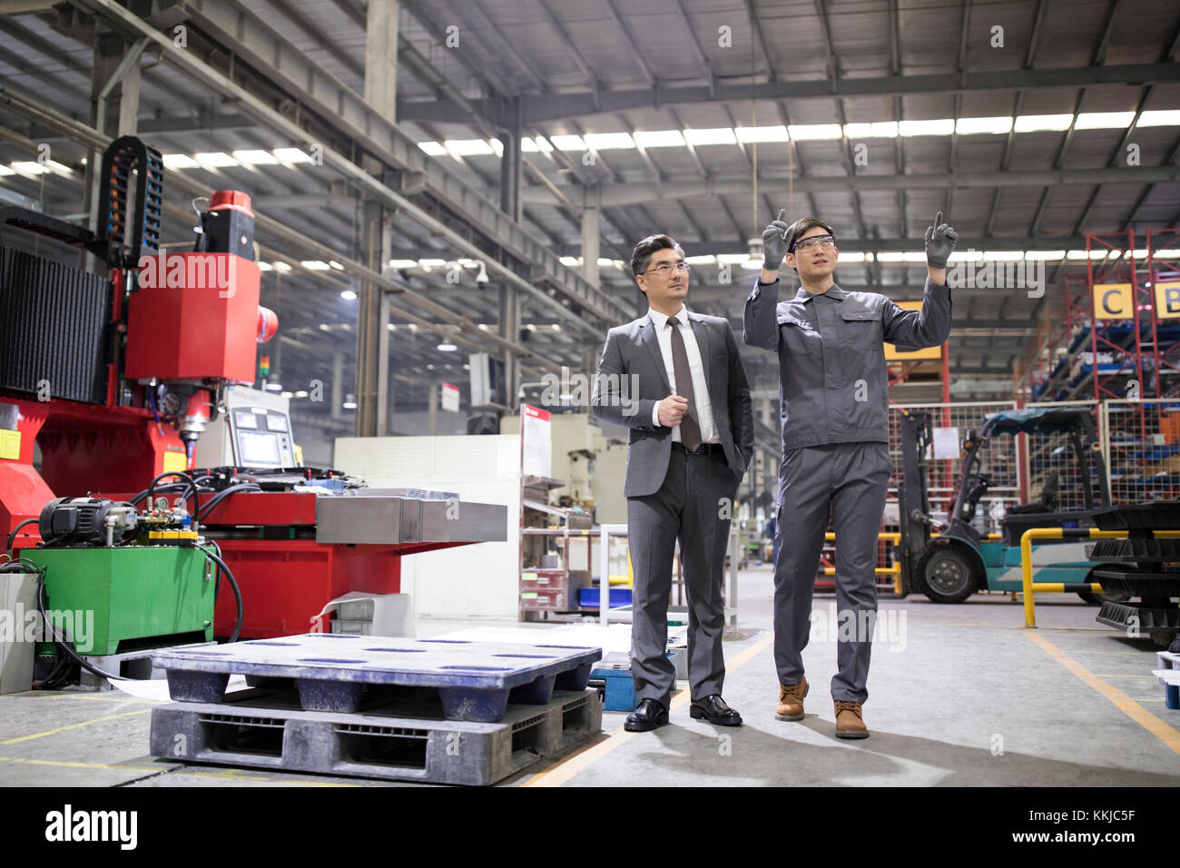 Chinese businessman and engineer talking in the factory Stock Photo - Alamy
