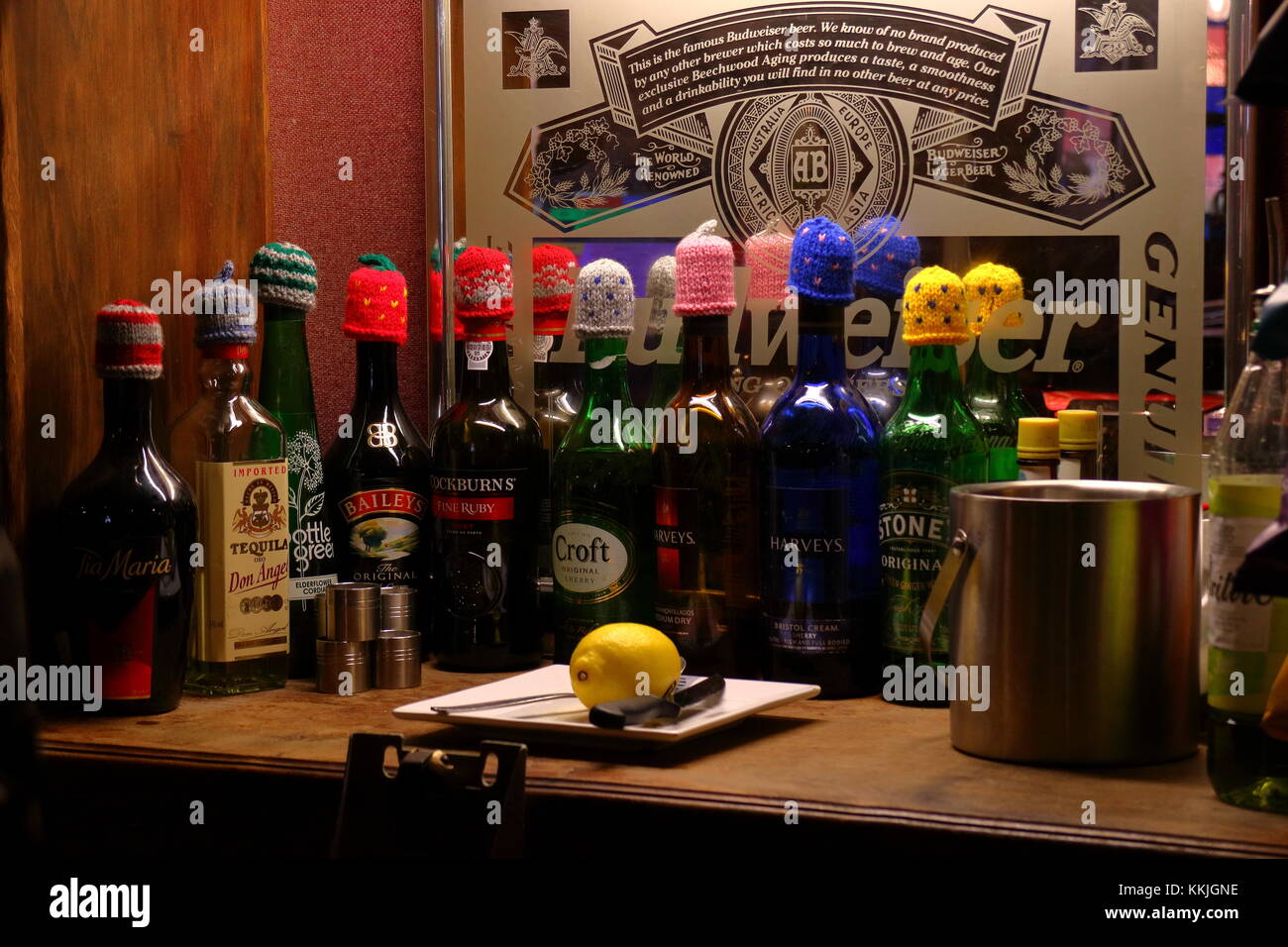 Liqueur and sherry bottles with Christmas woollen hats on their tops, on a bar in Devon, December 2017, England UK Stock Photo