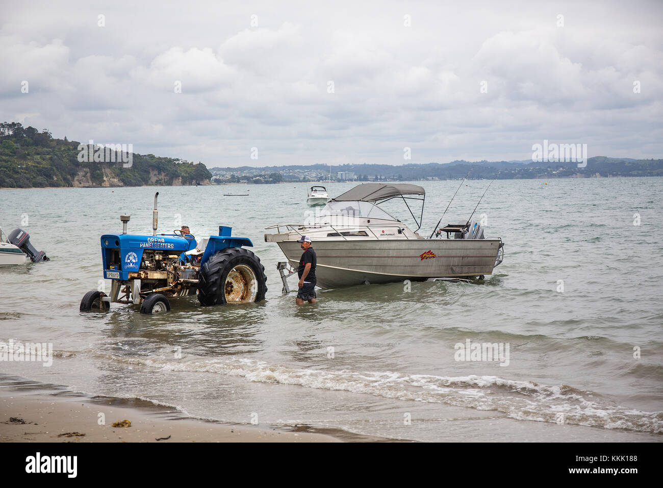The Stanmore Bay boat club tractor moves a fishermans boat from the bay  Whangaparaoa peninsular Auckland New Zealand Stock Photo
