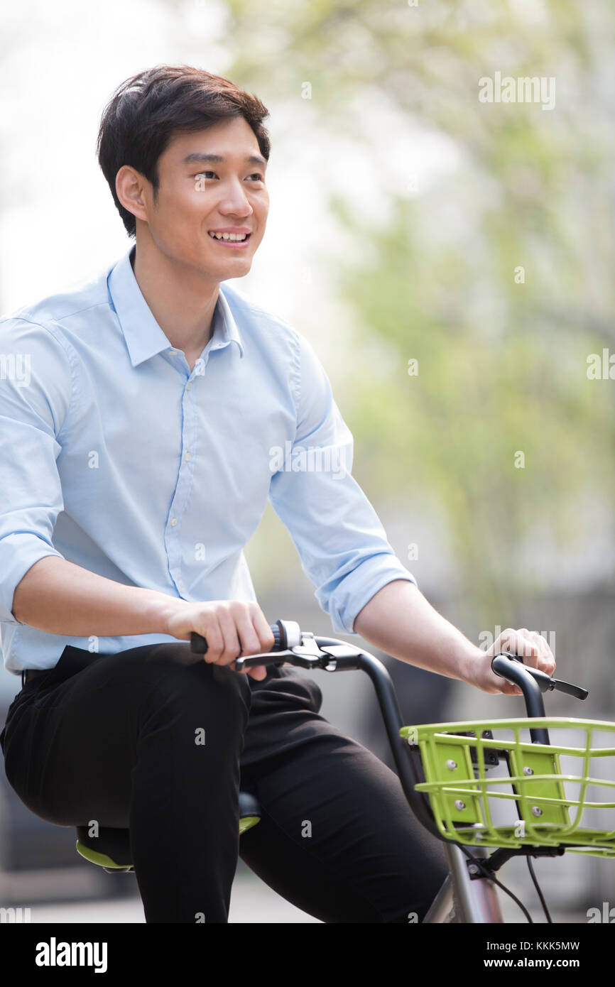Young Chinese man riding a share bike Stock Photo