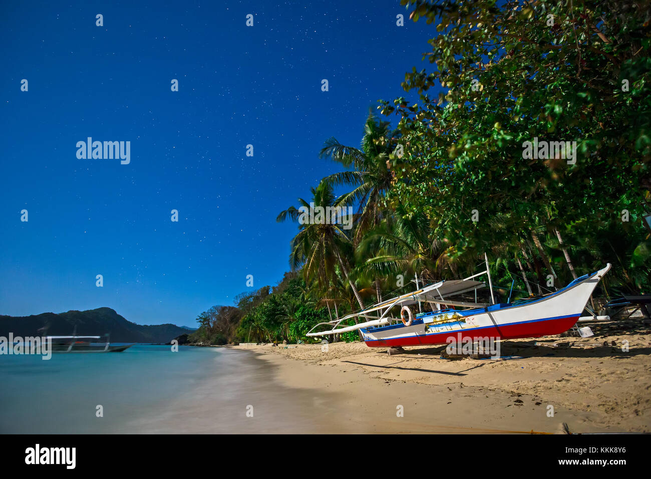 Moonscape in the Philippines with traditional banca boat on a beach, with starry sky above Stock Photo