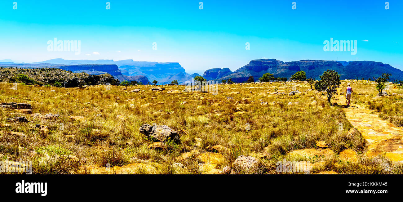 Panorama view of a Senior woman walking to the Three Rondavels viewpoint at the Blyde River Canyon at the Panorama Route in Mpumalanga , South Africa Stock Photo