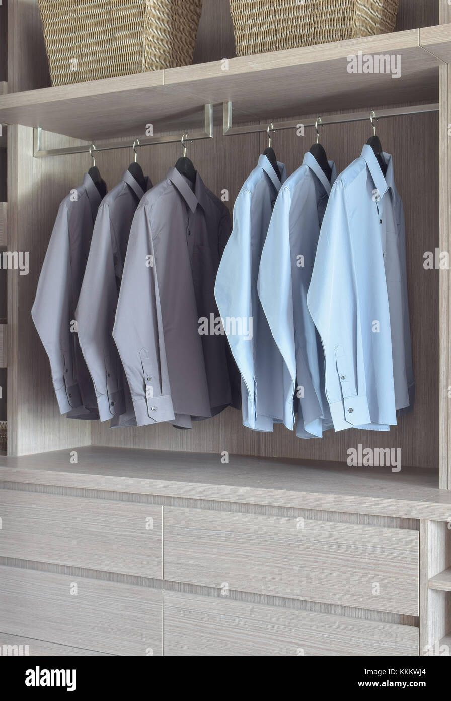Light blue and grey shirts in light wooden wardrobe Stock Photo Alamy