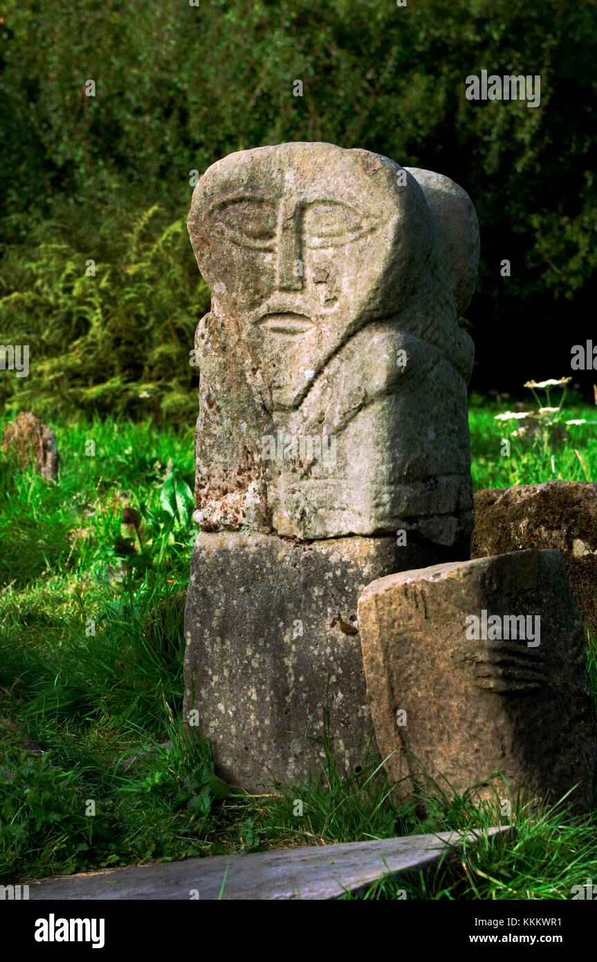 Caldragh cemetery on Boa Island, Lower Lough Erne, Ireland. Ancient Celtic prehistoric carved stone face called the Janus stone. Stock Photo