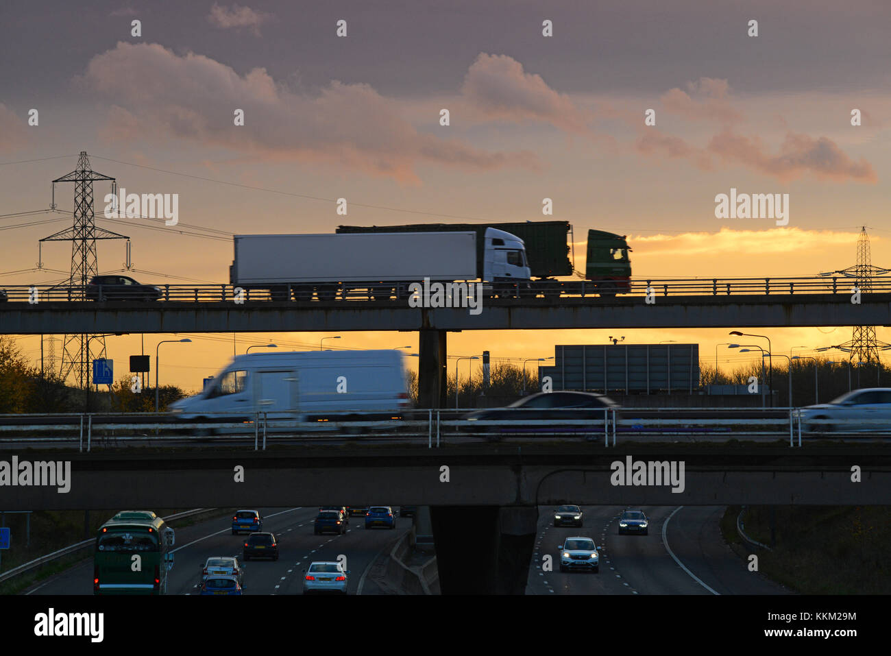 lorries crossing bridge at junction with m1 and m62 motorways at sunset leeds yorkshire united kingdom Stock Photo