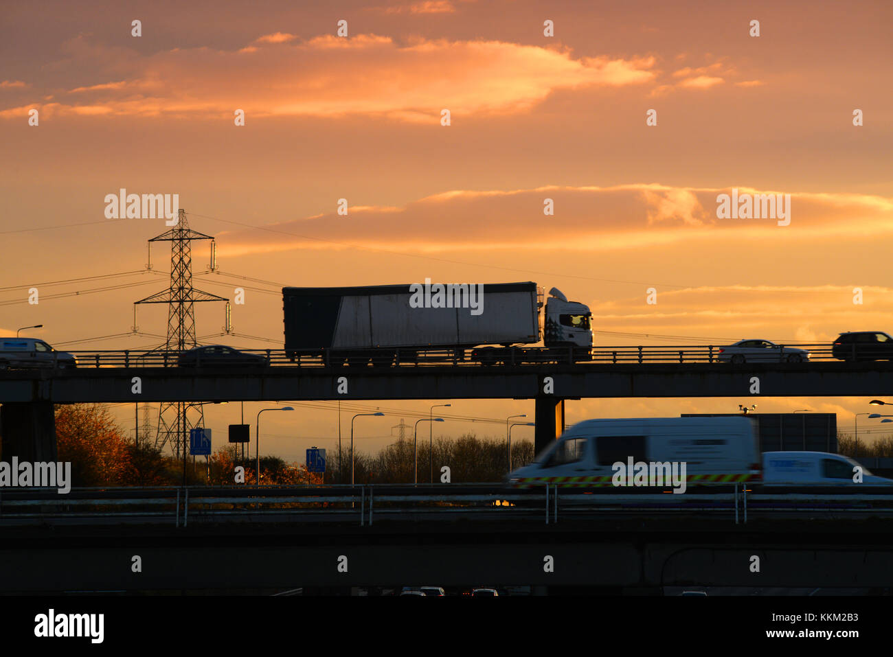 lorries crossing bridge at junction with m1 and m62 motorways at sunset leeds yorkshire united kingdom Stock Photo