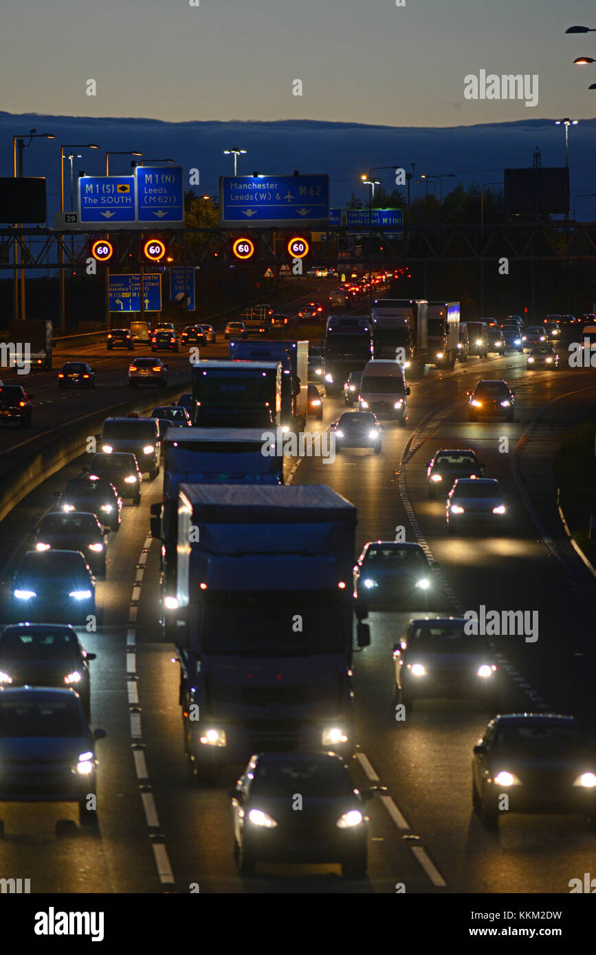 traffic jam by reduced speed limit and speed camera warning signs and speed on the m62 motorway leeds at dusk yorkshire united kingdom Stock Photo