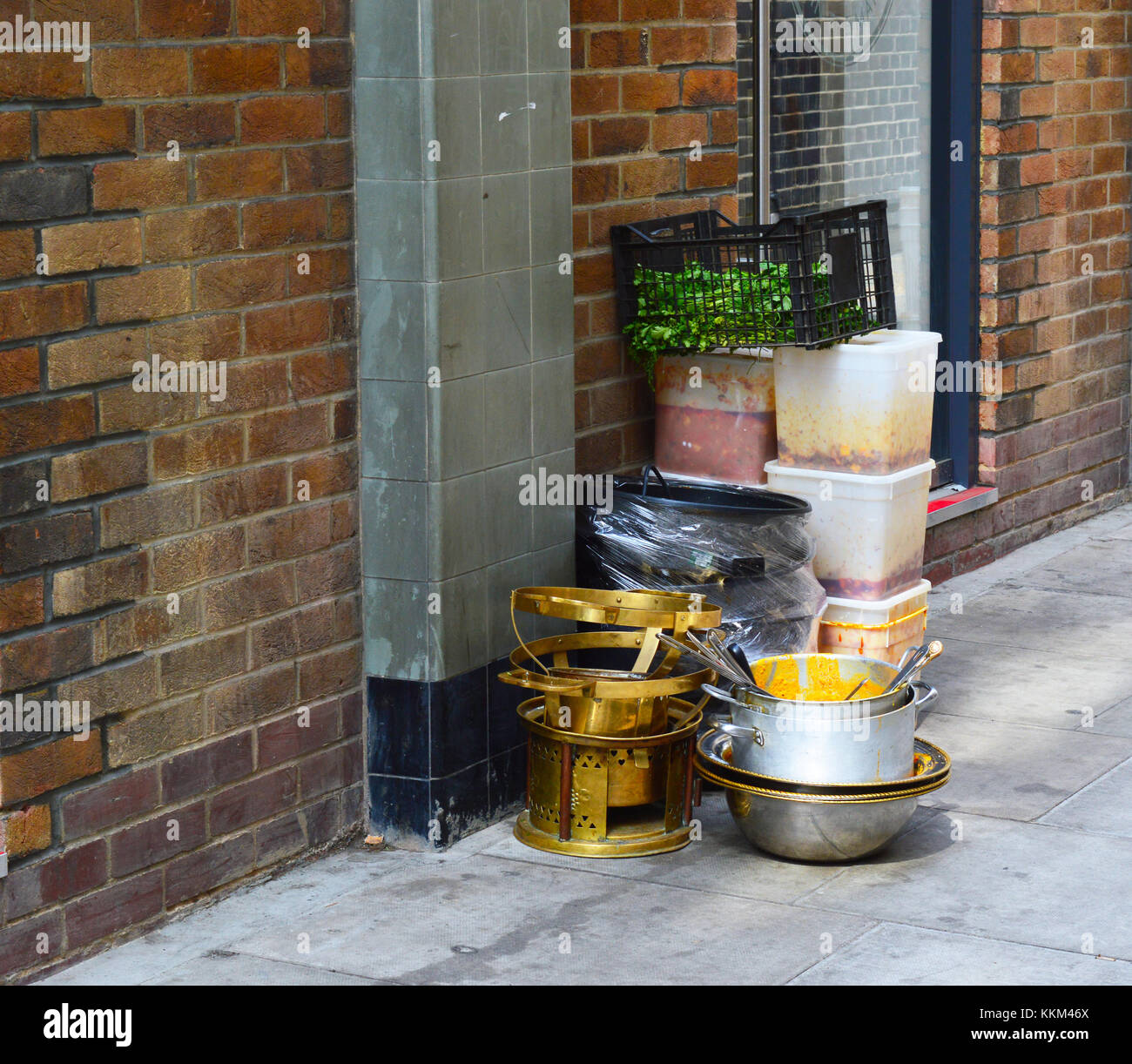 A photo of dirty dishes and food prep sitting out on the street Stock Photo