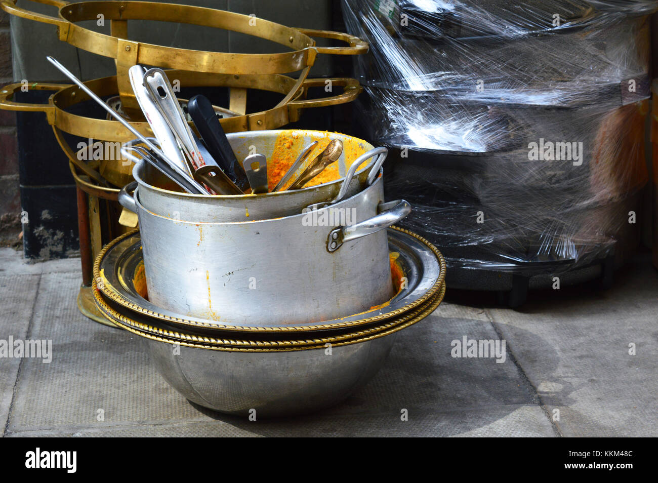 A stack of dirty cooking pots sitting on the street Stock Photo
