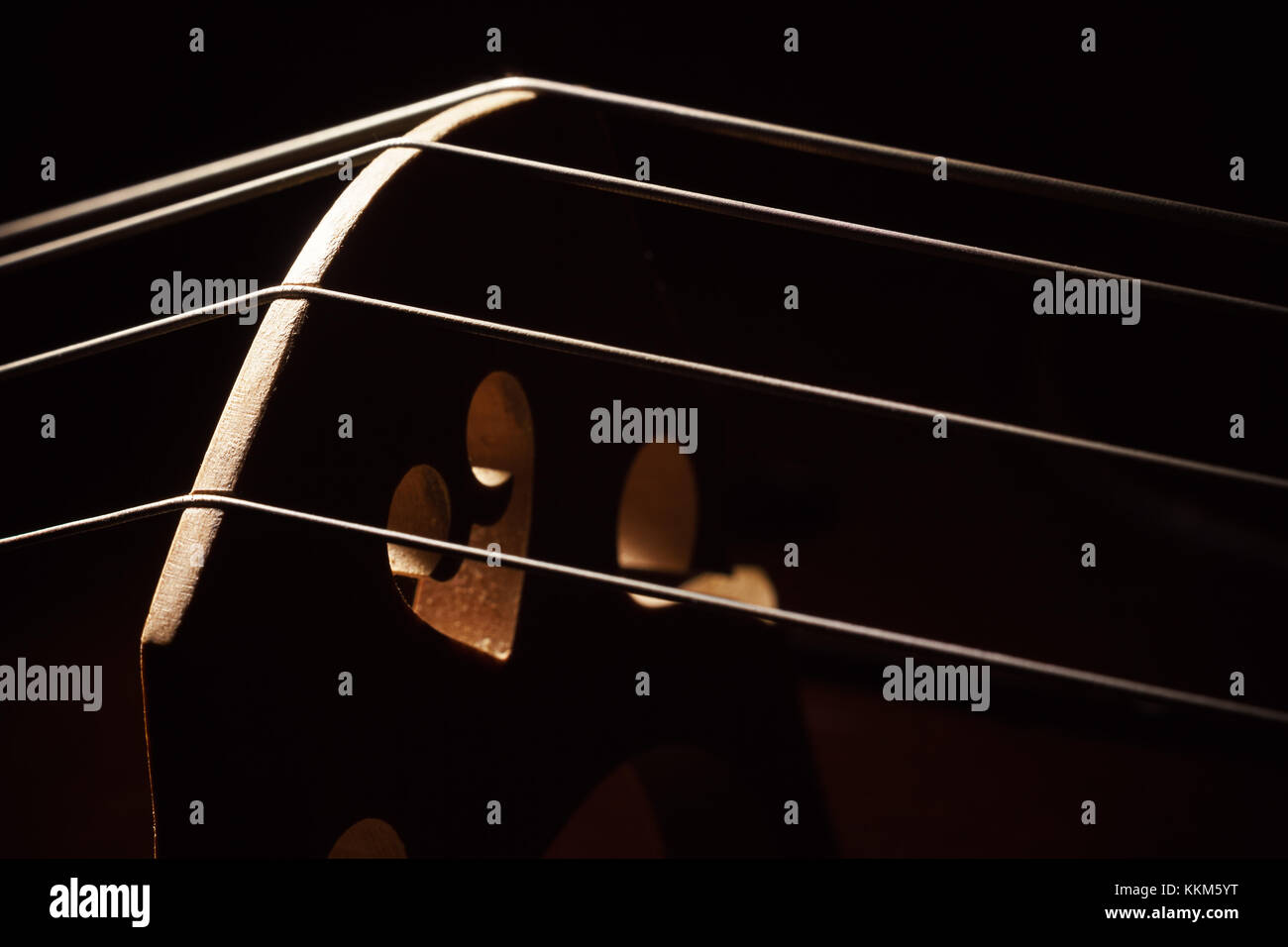 Closeup view of an old dusty cello, accentuated shapes with light. Stock Photo