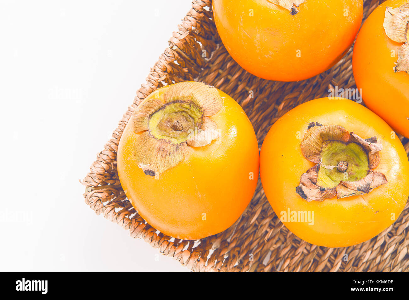Fresh natural kaki fruits in the basket on white background Stock Photo