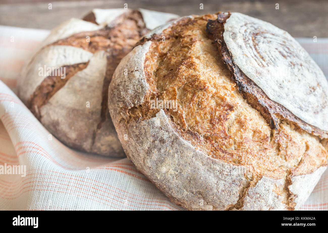 Two loaves of bread on the old-fashioned background Stock Photo - Alamy