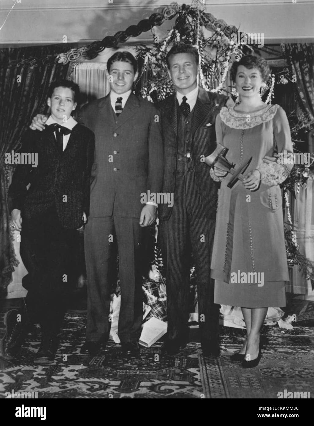 Repeat Yule Show: The Nelson family - Ozzie, Harriet and their sons, Rick, left, and David - are pictured in a scene from The Miracle,' a Christmas episode, first presented in 1953, scheduled for reshowing at 8:30 o'clock Wednesday night on Channel 4. The segment, filmed when the boys were 13 and 17, relates an incident in their father's boyhood. Rick is seen as the youthful Ozzie, David as his brother, Harriet as their mother and Ozzie as their late father. Adv of Ozzie and Harriet Nelson Family 1953 Stock Photo