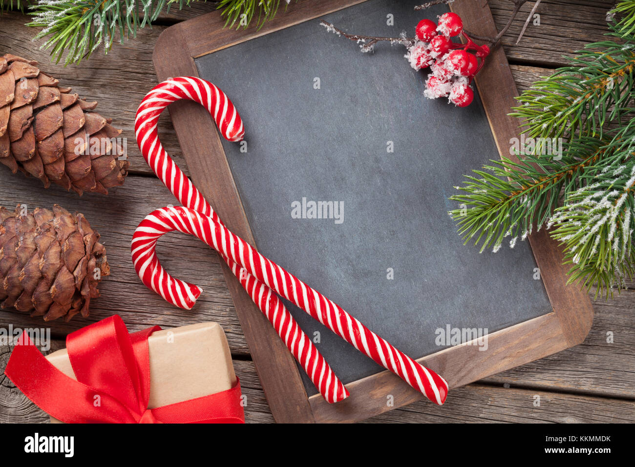 Christmas gift box, candy cane and snow fir tree on wooden table. Top ...