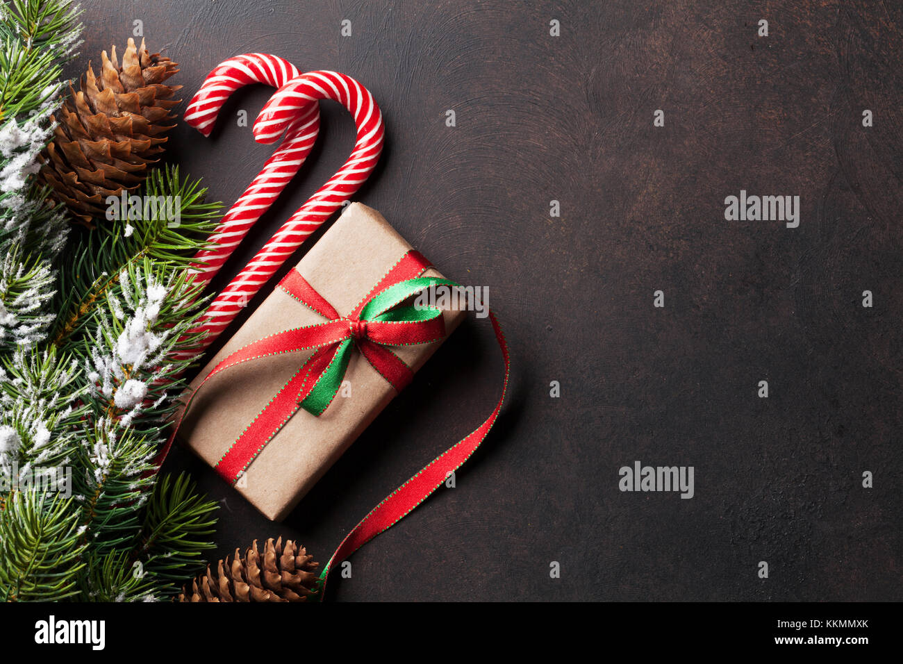 Christmas gift box, candy canes and snow fir tree on stone table. Top ...