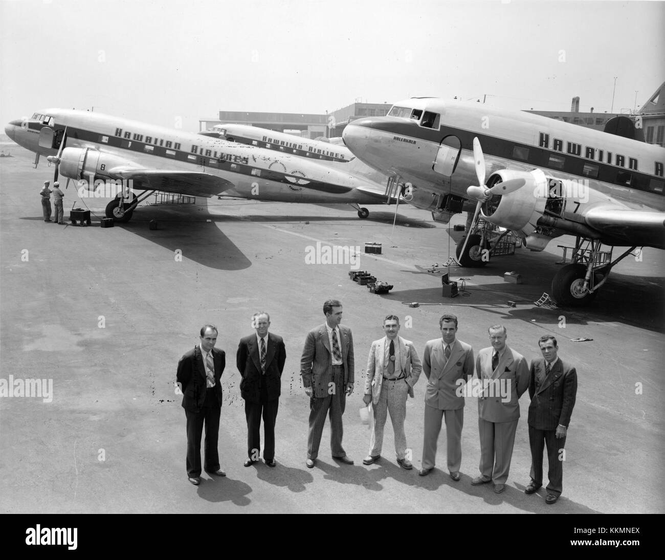 Douglas Aircraft Company personnel tasked with ferrying Hawaiian Airlines' new DC-3s from Oakland Field, Oakland, California, to John Rodgers Airport in Honolulu, Hawaii, pose in front of the three aircraft at Douglas Aircraft Company's Santa Monica, California, plant, sometime before the flight on August 27, 1941.  Aircraft are, front to back: Douglas DC-3 'Haleakala' (fleet no. 7), Douglas DC-3 'Waialeale' (fleet no. 8), and Douglas DC-3 'Mauna Loa' (r/n N33606). Hawaiian Airlines Douglas DC-3 at Santa Monica pre-delivery Stock Photo