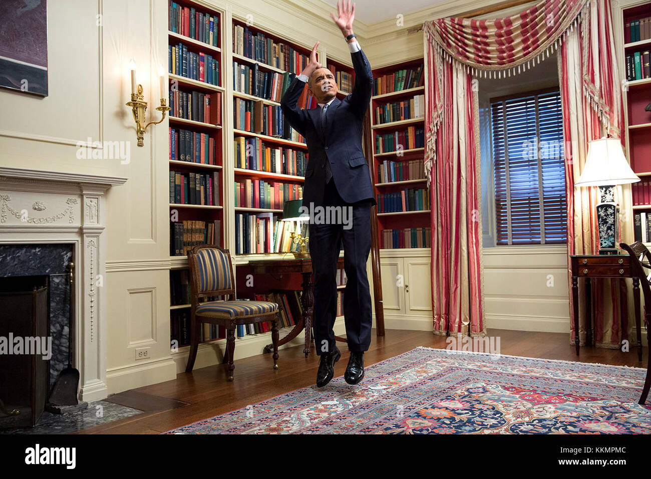 President Barack Obama feigns a jump shot during an Affordable Care Act video taping for BuzzFeed in the White House Library, Feb. 10, 2015. (Official White House Photo by Amanda Lucidon)  This official White House photograph is being made available only for publication by news organizations and/or for personal use printing by the subject(s) of the photograph. The photograph may not be manipulated in any way and may not be used in commercial or political materials, advertisements, emails, products, promotions that in any way suggests approval or endorsement of the President, the First Family,  Stock Photo