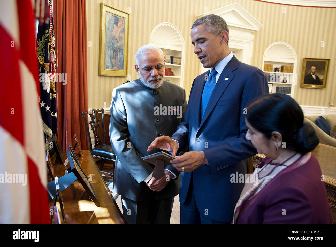 President Barack Obama discusses a photograph with Prime Minister Narendra Modi of India and Minister of External Affairs Sushma Swaraj following a bilateral meeting in the Oval Office, Sept. 30, 2014. Stock Photo