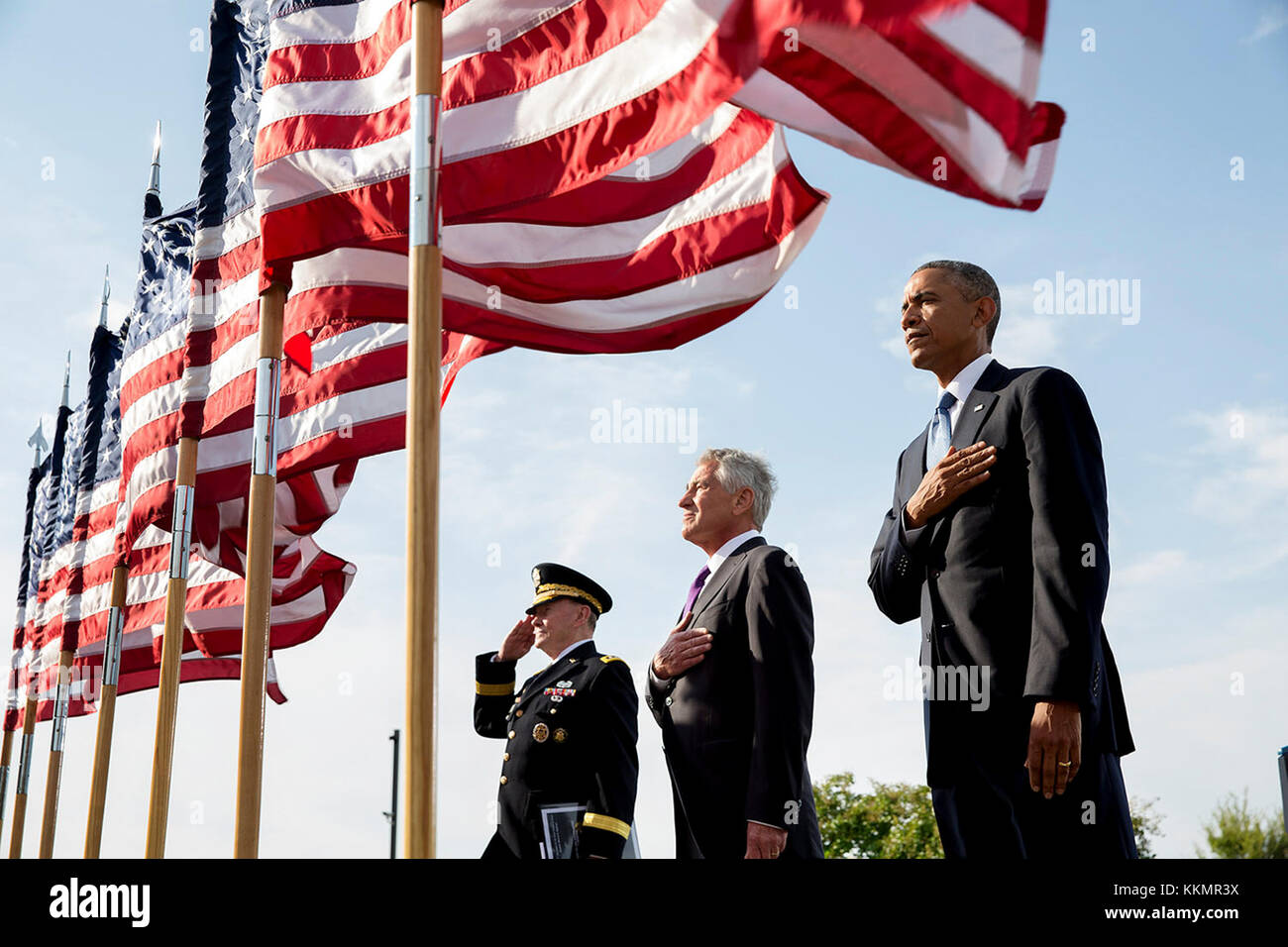 President Barack Obama, Defense Secretary Chuck Hagel, and Gen. Martin Dempsey, Chairman of the Joint Chiefs of Staff, listen to the national anthem during the September 11th Observance Ceremony at the Pentagon Memorial in Arlington, Va., Sept. 11, 2014. Stock Photo