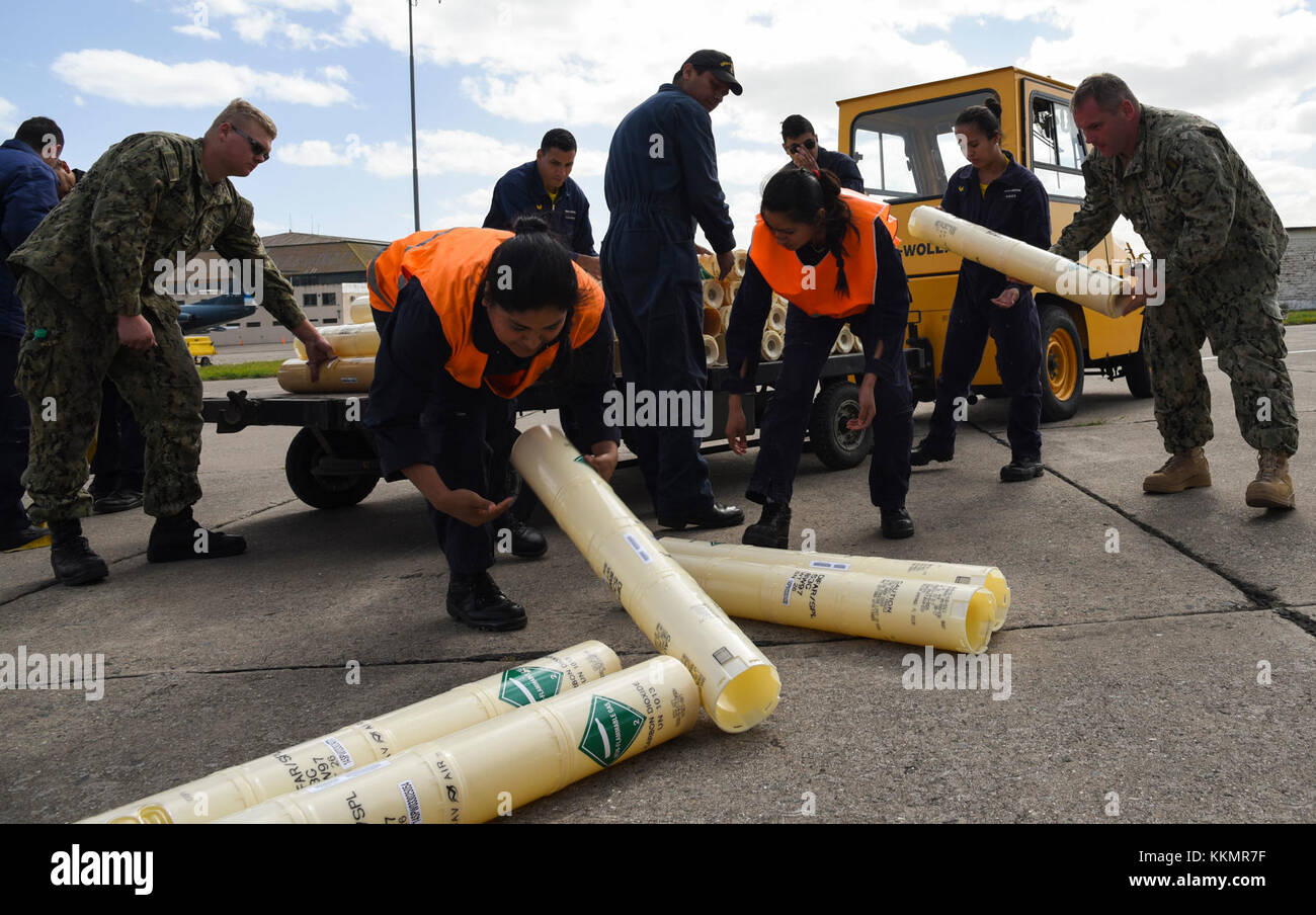 Bahia Blanca, ARGENTINA (Nov. 23, 2017) Members of the Argentine Navy help Sailors from the ‘Mad Foxes’ of Patrol Squadron (VP) 5and the ‘Pelicans’ of VP-45 load empty sonobouy casings onto a transport vehicle. Sailors from VP-5 and VP-45 are currently in Bahia Blanca as part of a detachment from Commander, Patrol and Reconnaissance Wing (CPRW) 11 assisting the Argentine military in their search for the missing Argentine submarine ARA San Juan. (U.S. Navy photo by Mass Communications Specialist 2nd Class Sean R. Morton/Released) Stock Photo