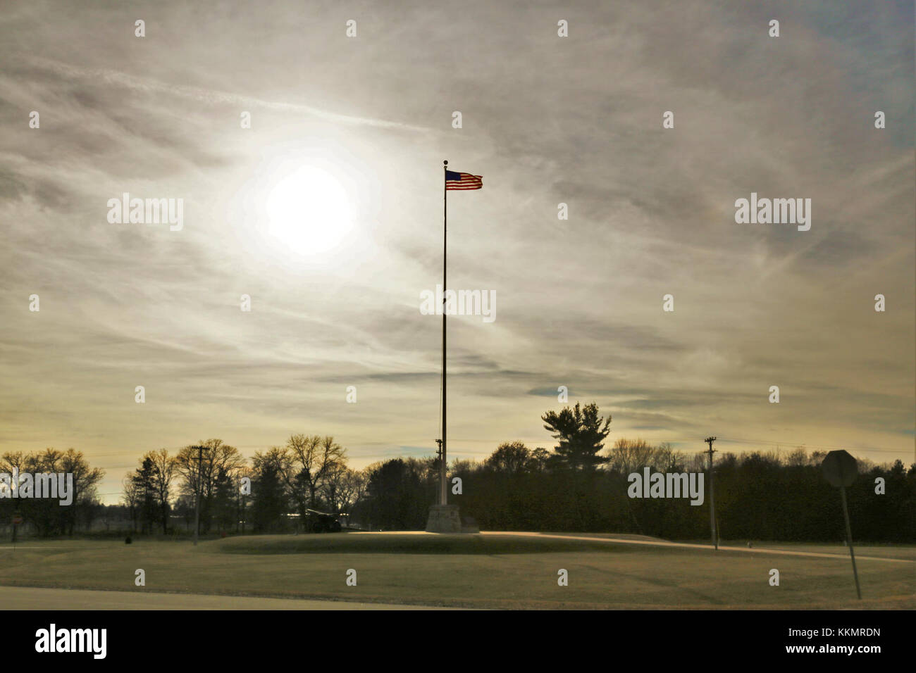 The flag of the United States of America is brightened by a backdrop of afternoon sun Nov. 27, 2017, while flying on the flagpole in front of Garrison Headquarters at Fort McCoy, Wis. The weather for late November was unseasonably warm with temperatures around 50 degrees Fahrenheit. (U.S. Army Photo by Scott T. Sturkol, Public Affairs Office, Fort McCoy, Wis.) Stock Photo