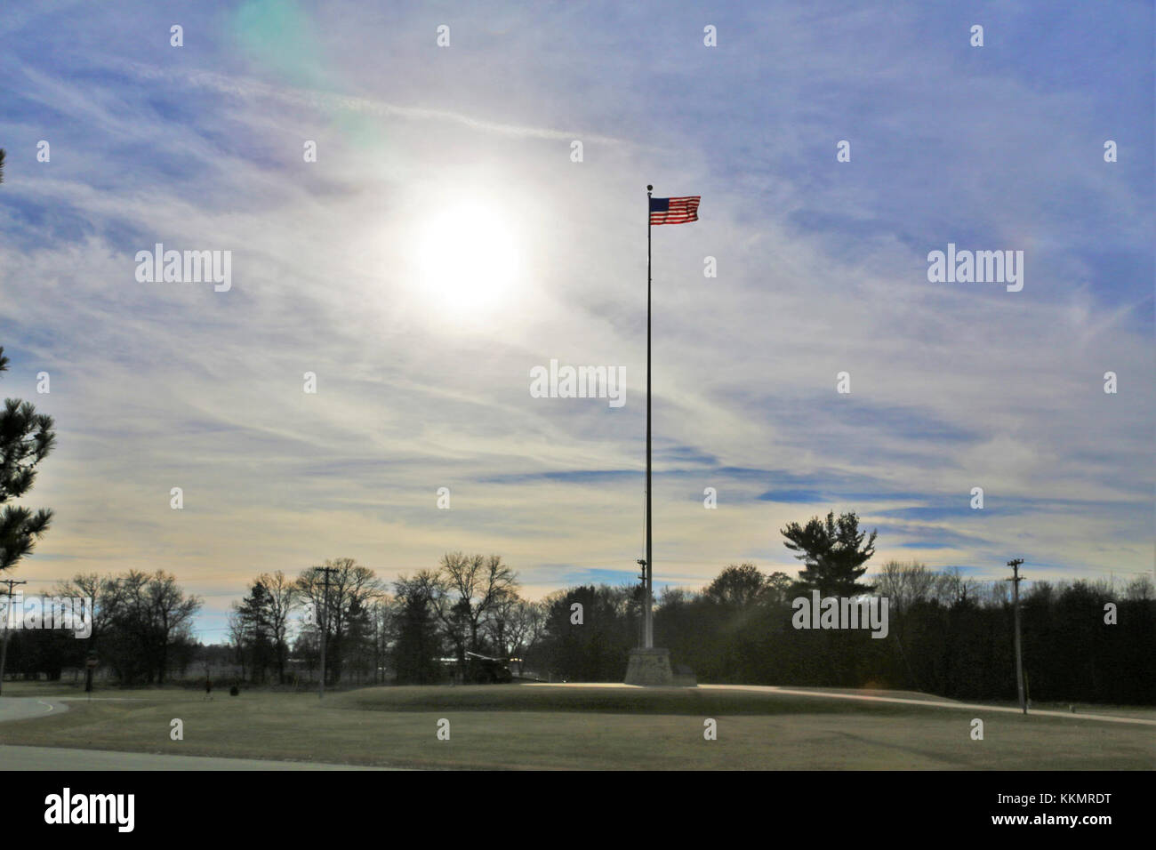 The flag of the United States of America is brightened by a backdrop of afternoon sun Nov. 27, 2017, while flying on the flagpole in front of Garrison Headquarters at Fort McCoy, Wis. The weather for late November was unseasonably warm with temperatures around 50 degrees Fahrenheit. (U.S. Army Photo by Scott T. Sturkol, Public Affairs Office, Fort McCoy, Wis.) Stock Photo