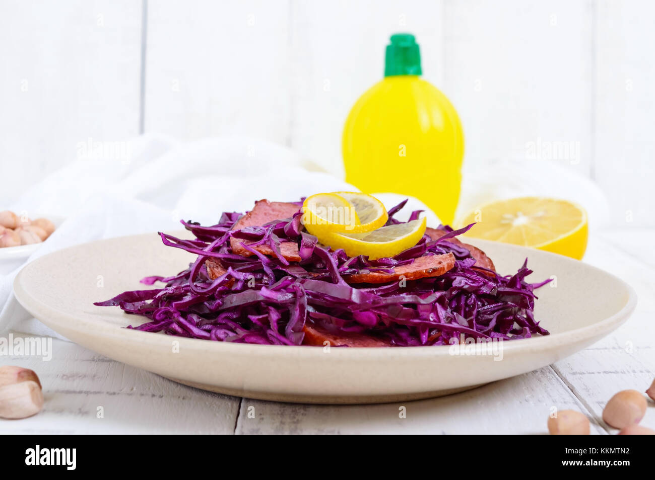 Salad of red cabbage, salami, peanuts on a white wooden background