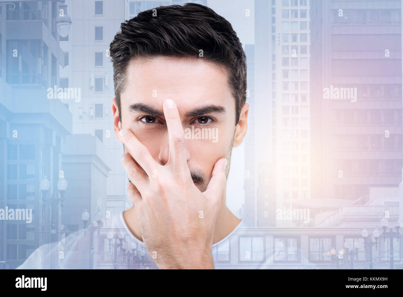 Attentive male person putting hand on his face Stock Photo