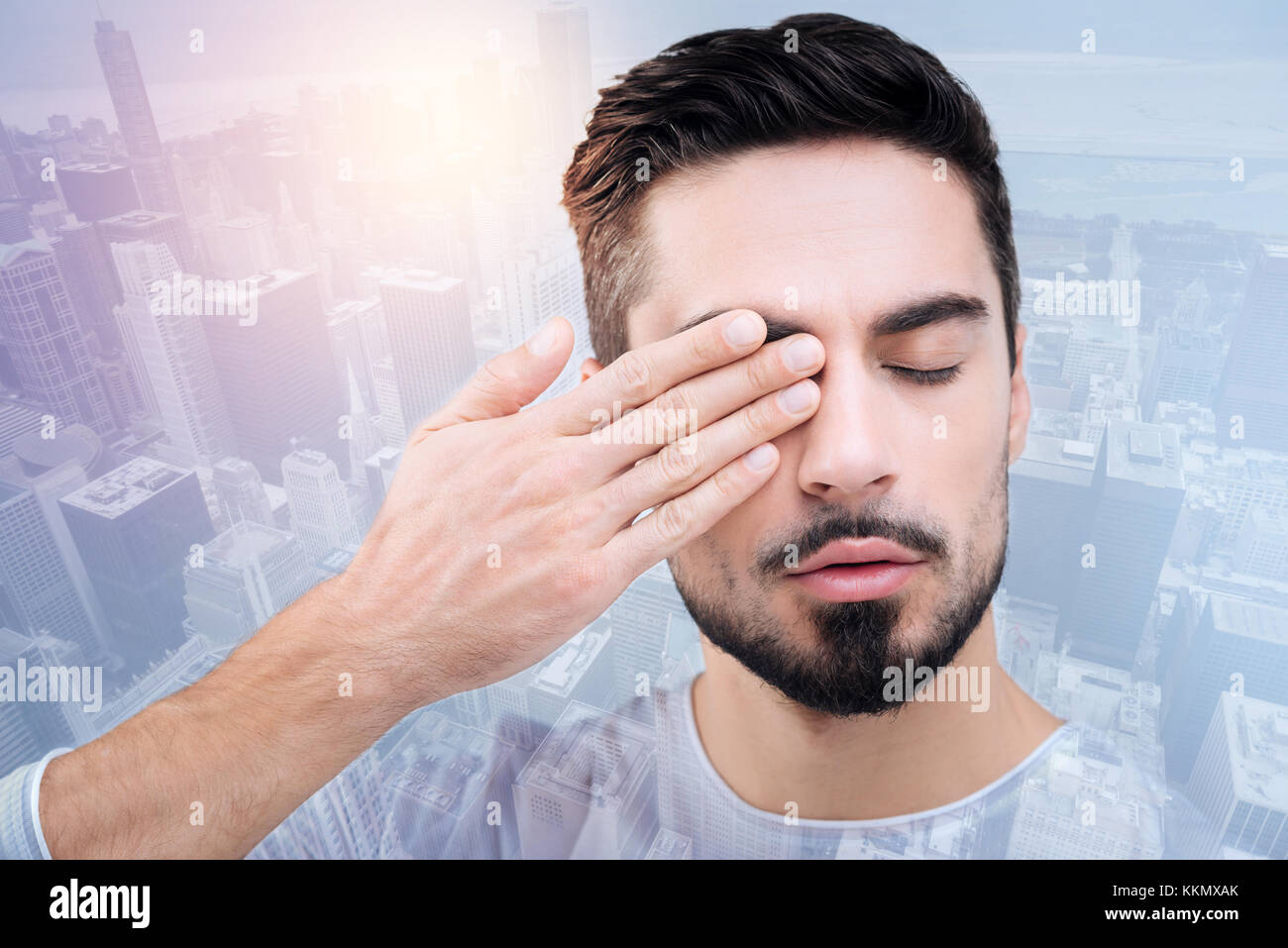 Exhausted young man touching his eye Stock Photo Alamy