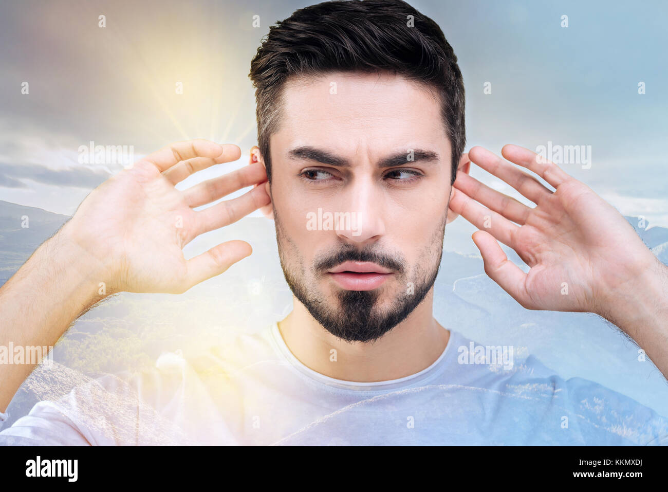 Disturbed man covering his ears Stock Photo