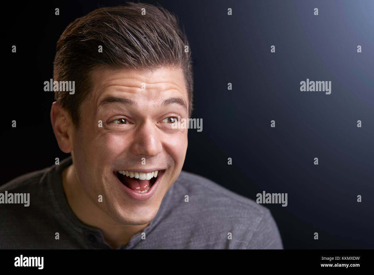 Portrait of a laughing young white man on black background Stock Photo