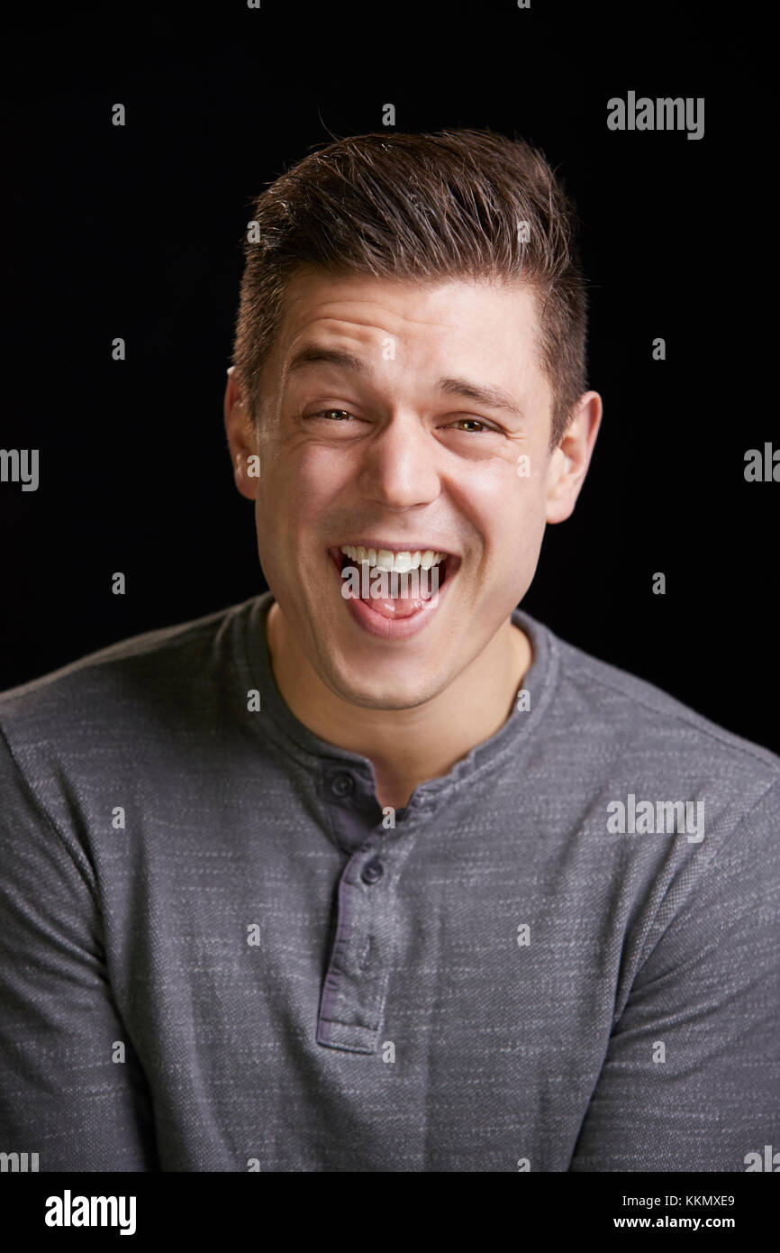 Laughing young white man looks to camera, vertical portrait Stock Photo