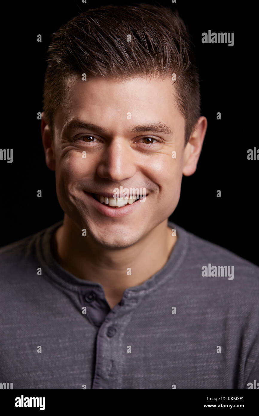 Portrait of a smiling young white man looking to camera, vertical Stock Photo