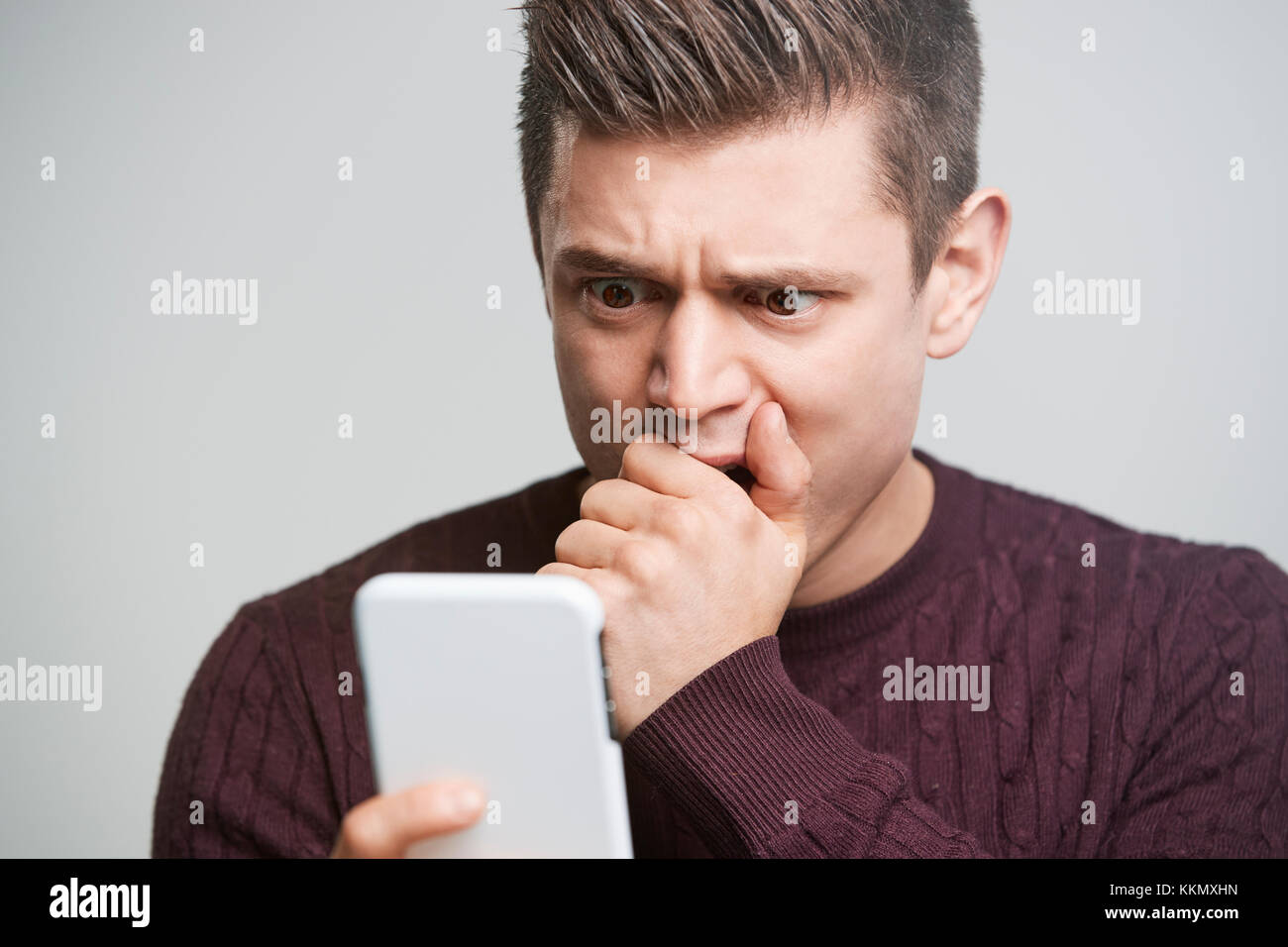 Cropped portrait of a shocked young man using a smartphone Stock Photo