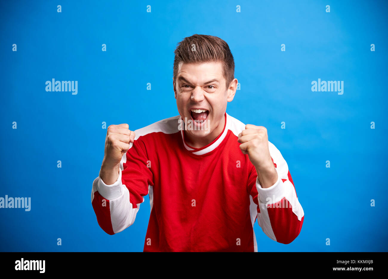 A young white male sports fan cheering and celebrating Stock Photo