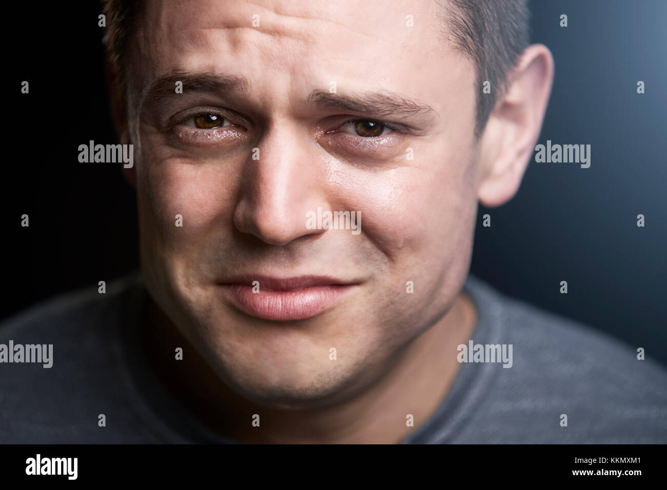 Close up portrait of upset young white man looking to camera Stock Photo