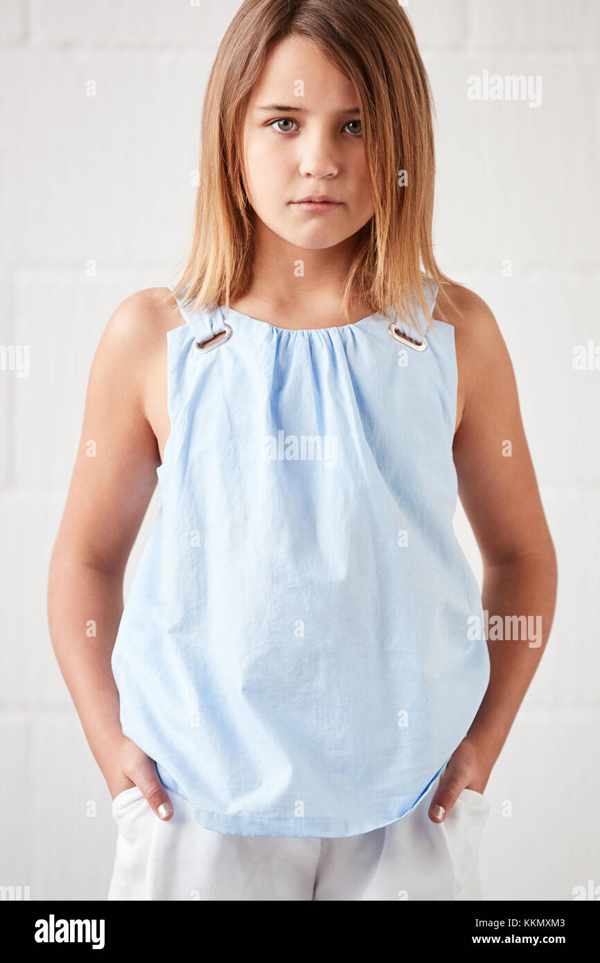 Portrait Of Stylish Young Girl Posing In Studio Against White Stock Photo