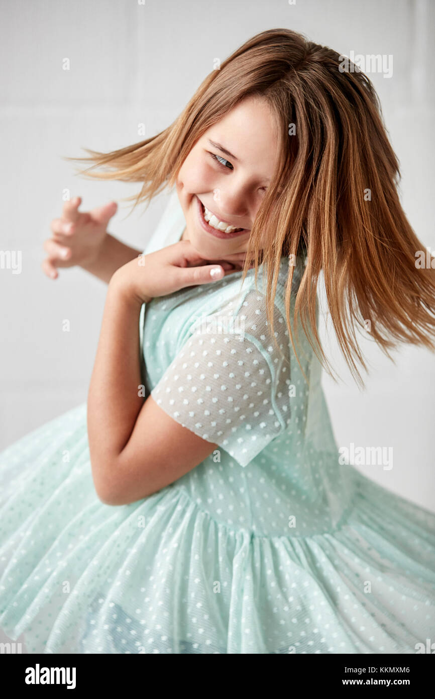 Happy Young Girl Posing In Studio Against White Wall Stock Photo