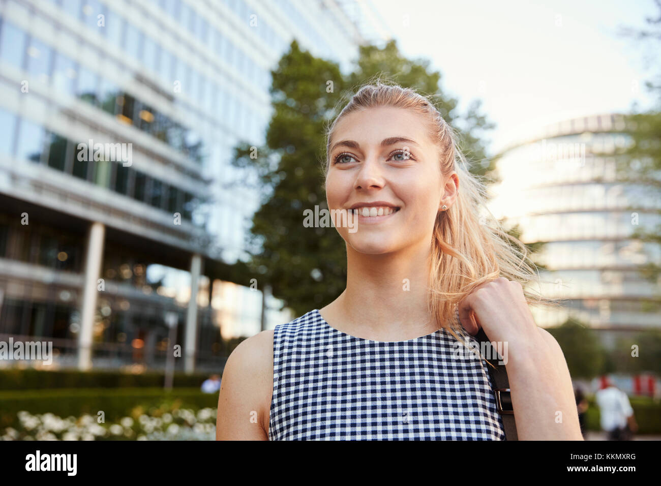 Businesswoman Walking Past Modern City Offices On Way To Work Stock Photo