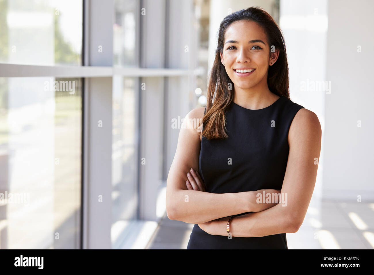 Portrait of young woman looking to camera with arms crossed Stock Photo