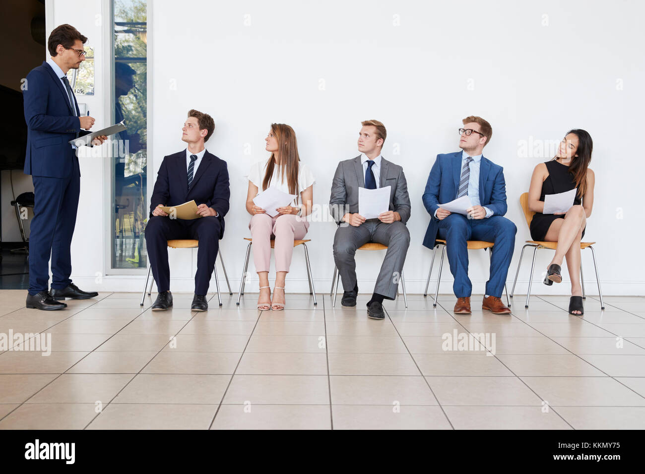 Recruiter and people waiting for job interviews, full length Stock Photo