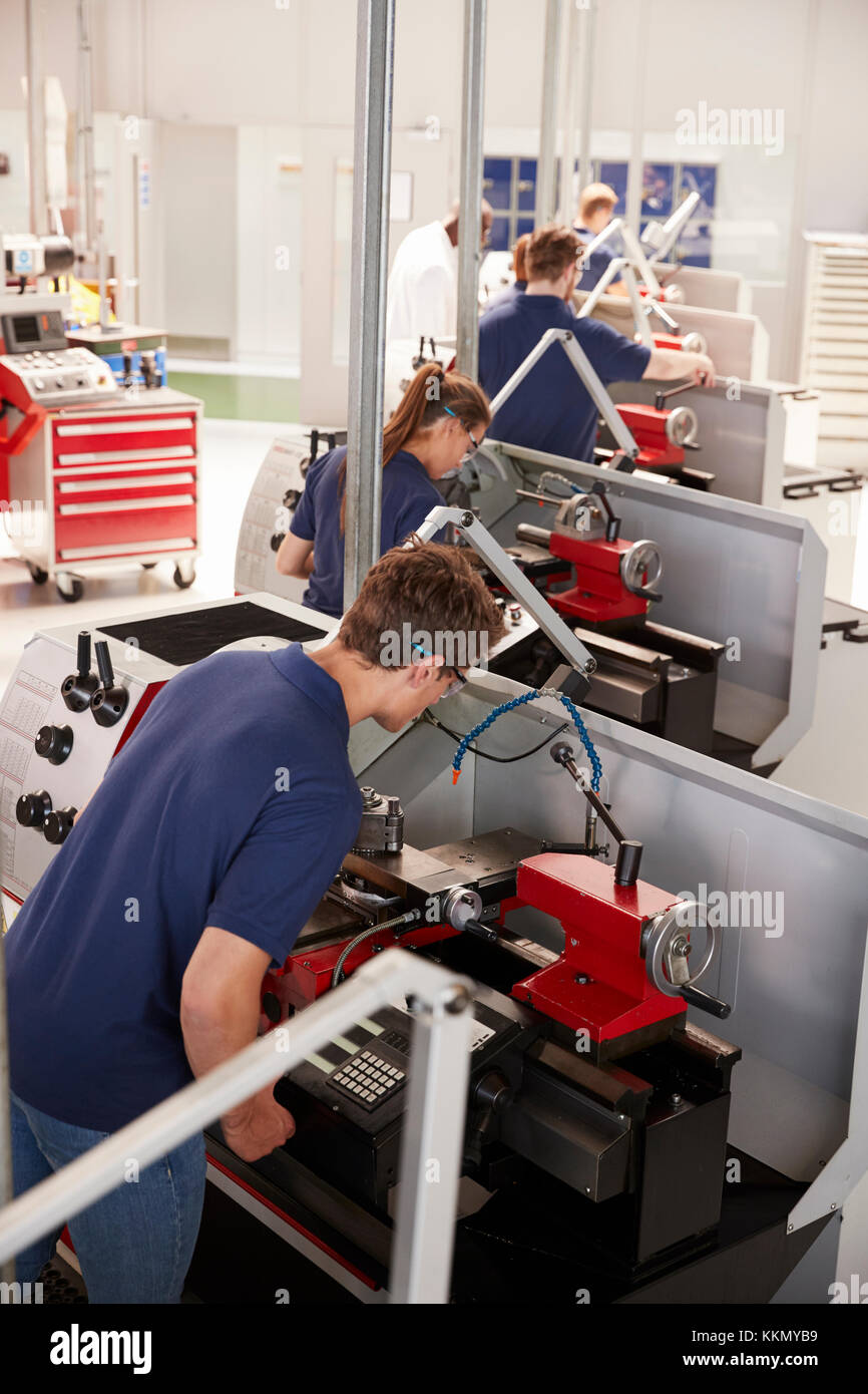 Trainee engineers operating equipment in a factory, vertical Stock Photo