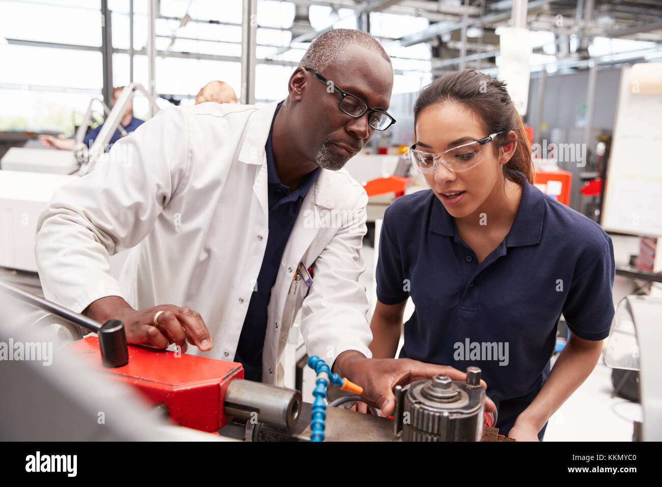 Engineer showing equipment to a female apprentice, close up Stock Photo