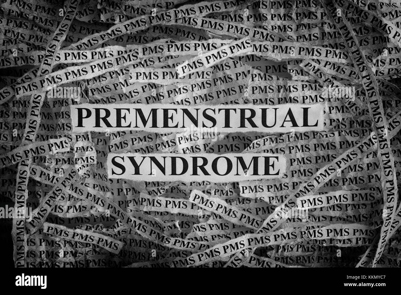 Premenstrual Syndrome. Torn pieces of paper with words Premenstrual Syndrome. Concept Image. Black and White. Closeup. Stock Photo