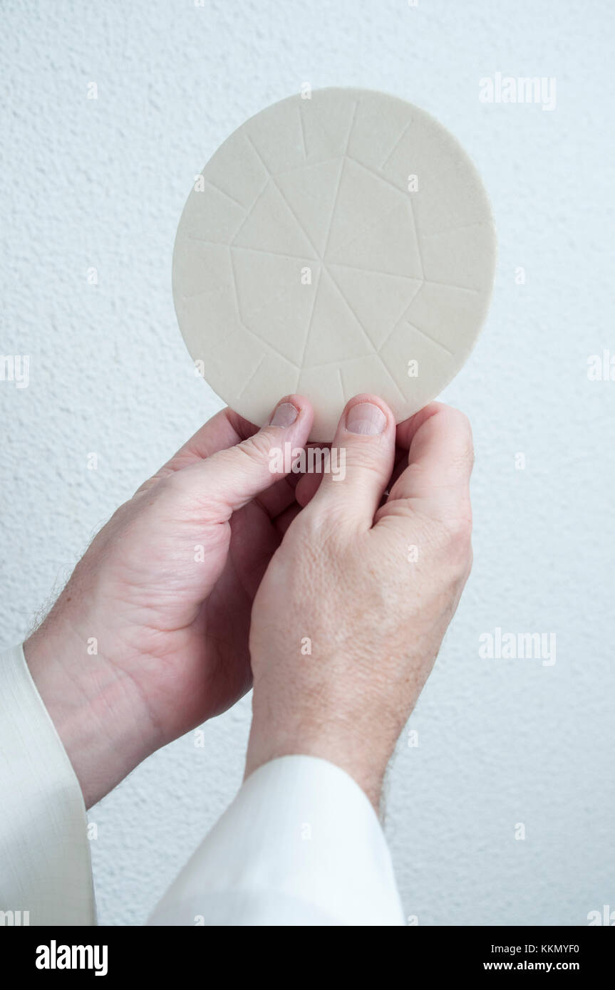 A priests hands holds the host bread that is consecrated in the